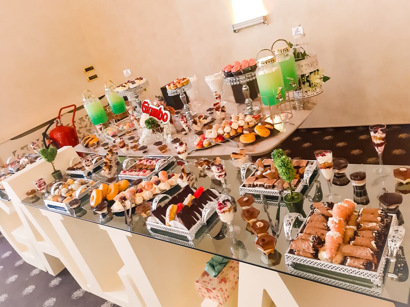 Masă dulce de eveniment pregătită de Cofetăria Giumbo, aranjată pe o masă amplă, cu prăjituri asortate și limonade