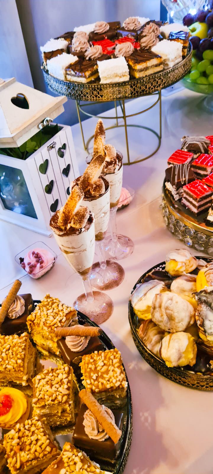 Masă dulce de eveniment pregătită de Cofetăria Giumbo, cu cupe de desert, prăjituri și fructe