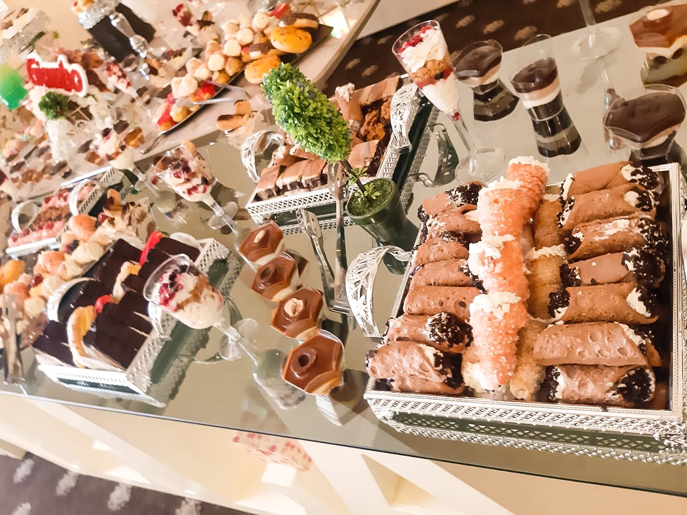 Masă dulce de eveniment pregătită de Cofetăria Giumbo, cu cannoli, prăjituri cu ciocolată și decor discret